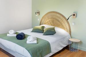 une chambre avec un grand lit avec des serviettes dessus dans l'établissement Chambres & sde privatives dans maison partagée, à Clisson