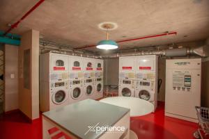 a laundry room with four washer and dryer machines at Teal at 12, City Views and Wonderland Vibes! in Hatillo