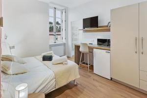 une chambre blanche avec un lit et un bureau dans l'établissement Chambres & sde privatives dans maison partagée, à Clisson