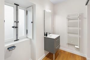 une salle de bains blanche avec un lavabo et un miroir dans l'établissement Chambres & sde privatives dans maison partagée, à Clisson 51 autres photos