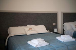 a bedroom with a bed with towels on it at Rosa Rooms Pompei in Pompei