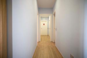 a hallway with white walls and a wooden floor at Rosa Rooms Pompei in Pompei