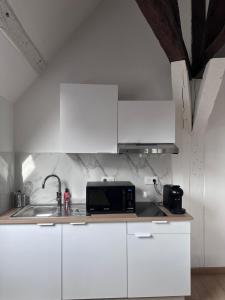 een witte keuken met een magnetron en een spoelbak bij Luxe Centre Orléans Chatelet I Exclusivité in Orléans