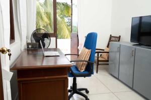 een kantoor met een bureau en een stoel met een laptop bij Mannat in Kandy