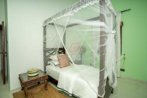 een slaapkamer met een wit hemelbed en een tafel bij Mannat in Kandy +9 foto's