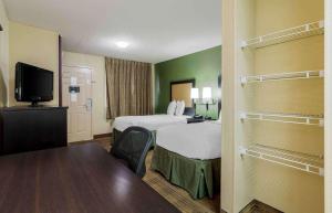 a hotel room with two beds and a flat screen tv at Extended Stay America Select Suites - Chattanooga - Airport in Chattanooga