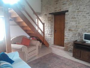 a living room with two chairs and a staircase at Gîte des Fraignaies in Saint-Juire-Champgillon