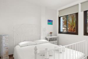 En eller flere senge i et værelse på MEDANO4YOU Oceanview Medano Center