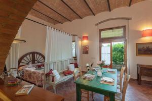 een woonkamer met een tafel en een slaapkamer bij Podere Oliveta - 5 appartamenti con Piscina e Vista in Poggibonsi