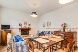 een woonkamer met een tafel, stoelen en een bank bij Podere Oliveta - 5 appartamenti con Piscina e Vista in Poggibonsi