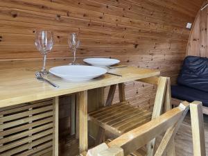 a wooden table with two plates and wine glasses at Meadow - Uk48483 in Dalton in Furness