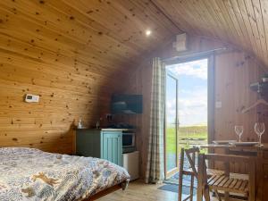 a bedroom with wooden walls and a bed and a table at Meadow - Uk48483 in Dalton in Furness +6 photos