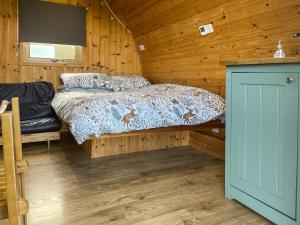 a bedroom with a bed in a wooden cabin at Meadow - Uk48483 in Dalton in Furness