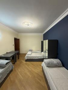 a room with two beds and a blue wall at Guesthouse MA in Yerevan +33 photos