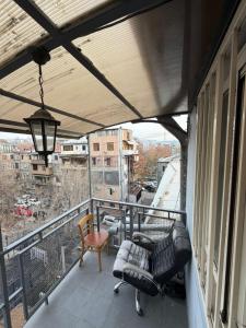 a balcony with a couch and chairs on a balcony at Guesthouse MA in Yerevan