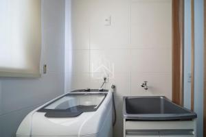 eine weiße Küche mit einem Waschbecken und einem Waschbecken in der Unterkunft Cobertura 07 Antares Bombinhas in Bombinhas + 54 Fotos