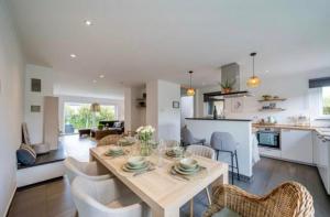 a kitchen and living room with a table and chairs at Green& Light House16 in Kettenis