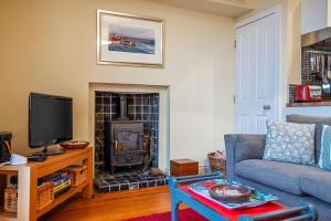 a living room with a couch and a fireplace at Little Net House - Pittenweem in Pittenweem