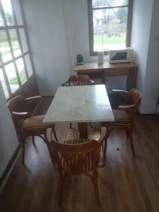 ein Tisch und Stühle in einem Raum mit einem Schreibtisch in der Unterkunft Relax Thermal Villapark Csokonyavisonta fürdőbelépővel in Csokonyavisonta + 23 Fotos