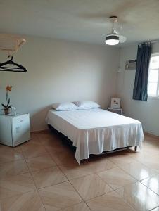a bedroom with a bed with a white bedspread at Pousada Fonte da Samaritana in Vila Velha