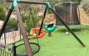 - une balançoire dans une cour avec une aire de jeux dans l'établissement Maison Avec Piscine, à Gémenos