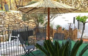 une table et deux chaises sous un parasol dans l'établissement Maison Avec Piscine, à Gémenos 5 autres photos