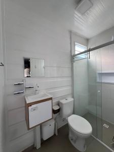 un bagno bianco con un water e un lavandino di Containers Schmitz - Kitnet 1 a Florianópolis
