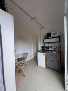 una piccola cucina con tavolo, tavolo e sedia di Containers Schmitz - Kitnet 1 a Florianópolis