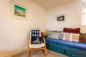 a room with a blue bed and a chair at Harbour View Apartment - Crail in Crail