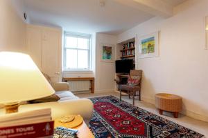 a living room with a couch and a tv at Harbour View Apartment - Crail in Crail