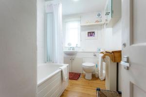 a bathroom with a tub and a toilet and a sink at Harbour View Apartment - Crail in Crail +29 photos