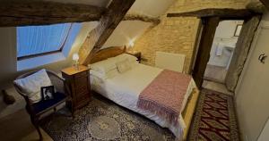 ein Schlafzimmer mit einem Bett und einem Stuhl in einem Gebäude in der Unterkunft Le Gîte Pérard in Caylus + 53 Fotos