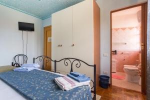 a bedroom with a bed and a bathroom with a toilet at B&B Il Mirto in Oristano