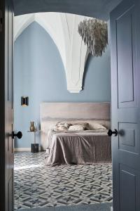 een slaapkamer met een bed en een blauwe muur bij Dimora Cocchi in Carovigno