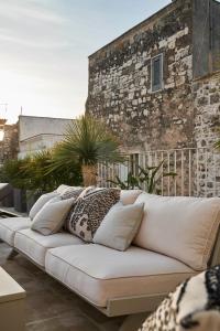 een witte bank met kussens op een patio bij Dimora Cocchi in Carovigno