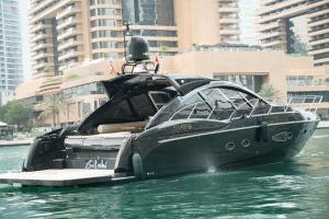 a black boat in the water with buildings in the background at Yacht Azimut Atlantis 50 in Dubai +2 photos