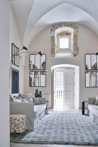 een woonkamer met een bank en een deur bij Dimora Cocchi in Carovigno