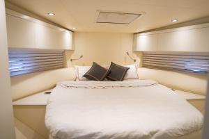 a large bed in a room with two windows at Yacht Azimut Atlantis 50 in Dubai