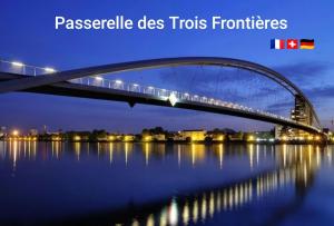 a bridge over the water at night at Central Studio - Proche Bâle & St Louis in Saint-Louis +2 photos