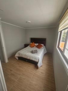 a bedroom with a bed with orange pillows on it at Casa con estacionamiento privado in San Carlos