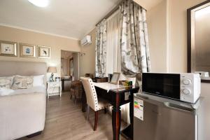 een kamer met een bed en een bureau met een televisie bij Nautilus Guesthouse in Port Elizabeth