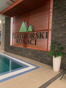 a sign on the side of a building with a swimming pool at Beli Apartman u Zlatiborskim konacima Bele vode bb in Zlatibor +11 photos