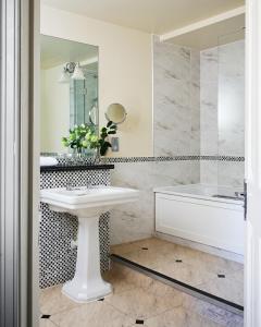 a bathroom with a sink and a tub and a mirror at Ettington Park Hotel, Stratford-upon-Avon in Stratford-upon-Avon +60 photos