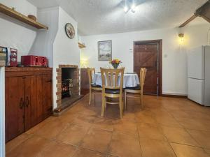 een keuken en eetkamer met een tafel en een open haard bij Jasmine Cottage - Uk50585 in Bintree
