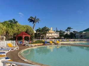 a swimming pool with chairs and a gazebo at Ti coin de paradis Anse des Rochers in Saint-François