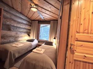 a room with three beds in a log cabin at Rukan Salonkilomat in Ruka