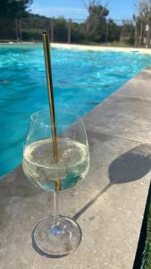 een glas met een stokje erin naast een zwembad bij Auberge Gardoise in Vallérargues
