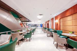a dining room with green chairs and tables at The Venue Al Harithia Hotel in Medina