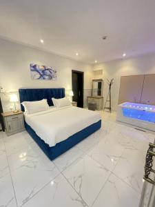 a bedroom with a large bed and a bath tub at شقة بنظام فيلا مستقلة بالكورنيش apartment with villa system in Jeddah