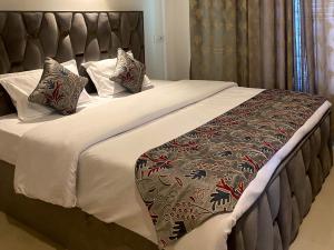 a bedroom with a large bed with white sheets and pillows at The Meer Mansion in Srinagar +9 photos